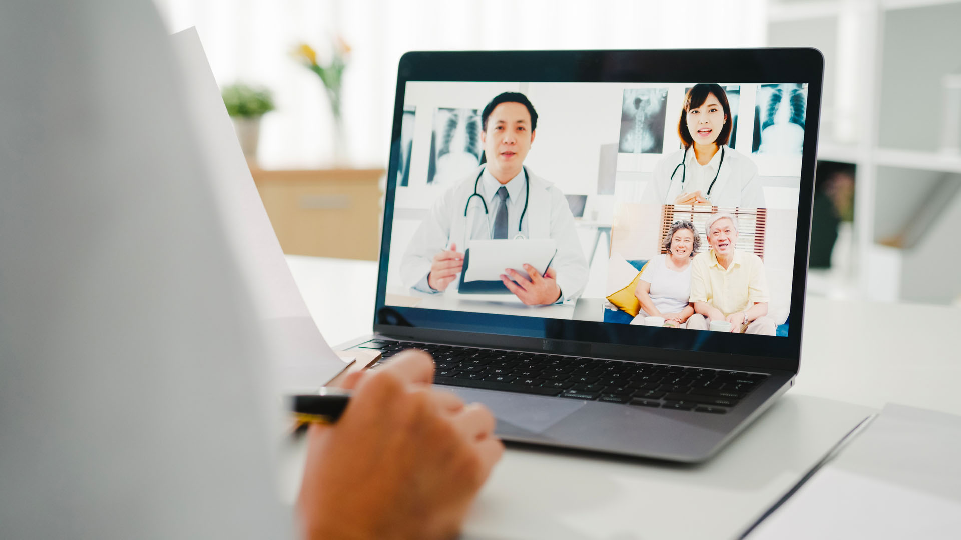 Médico atendiendo una videoconsulta desde una computadora portátil