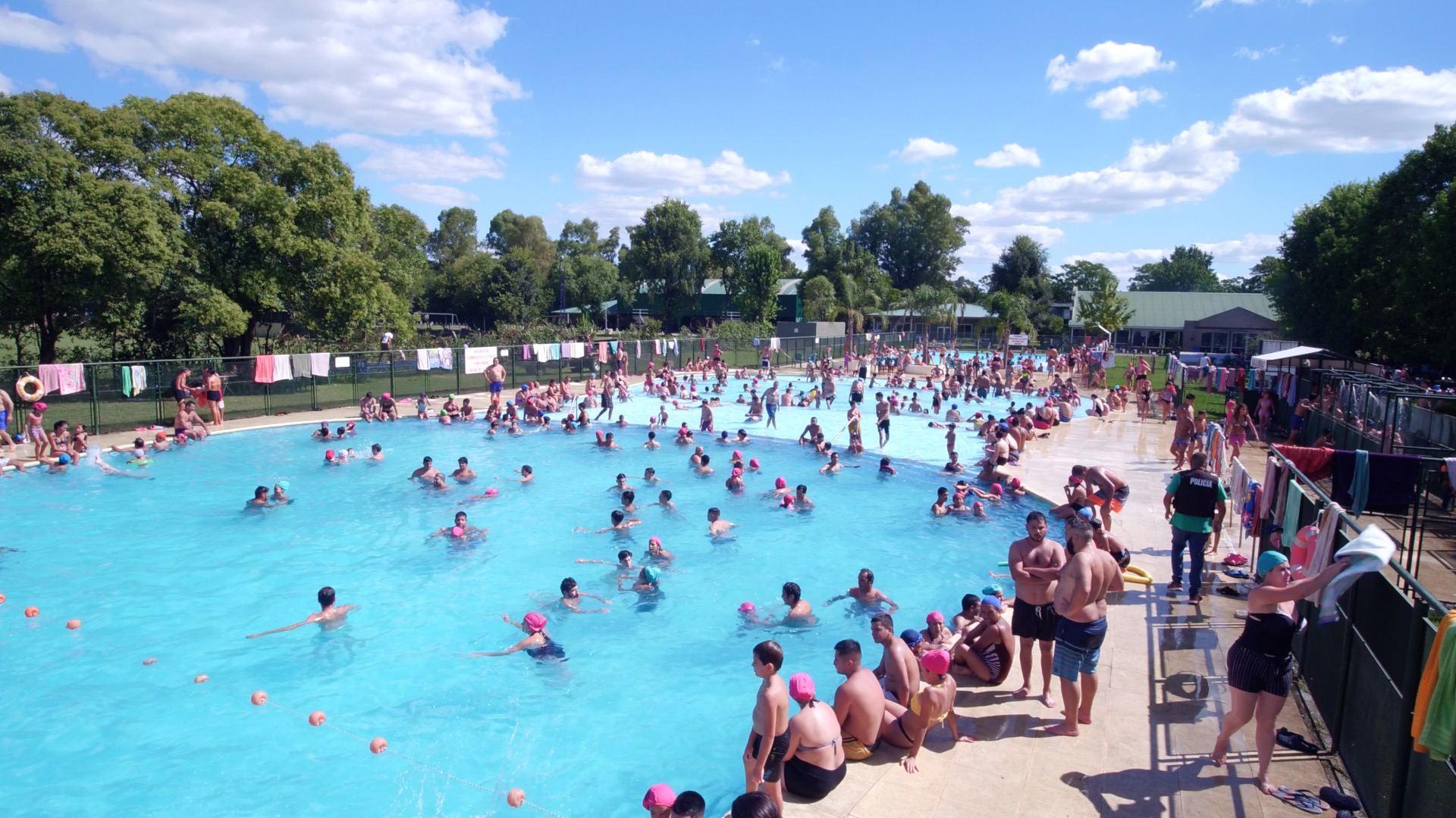 Pileta del camping llena de familias en un día de sol